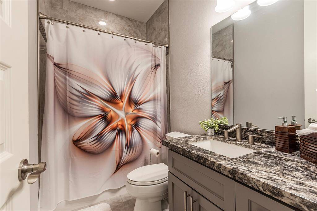 Third full bathroom upstairs with with granite countertop vanity and shower/tub combination with full tile surrounding.