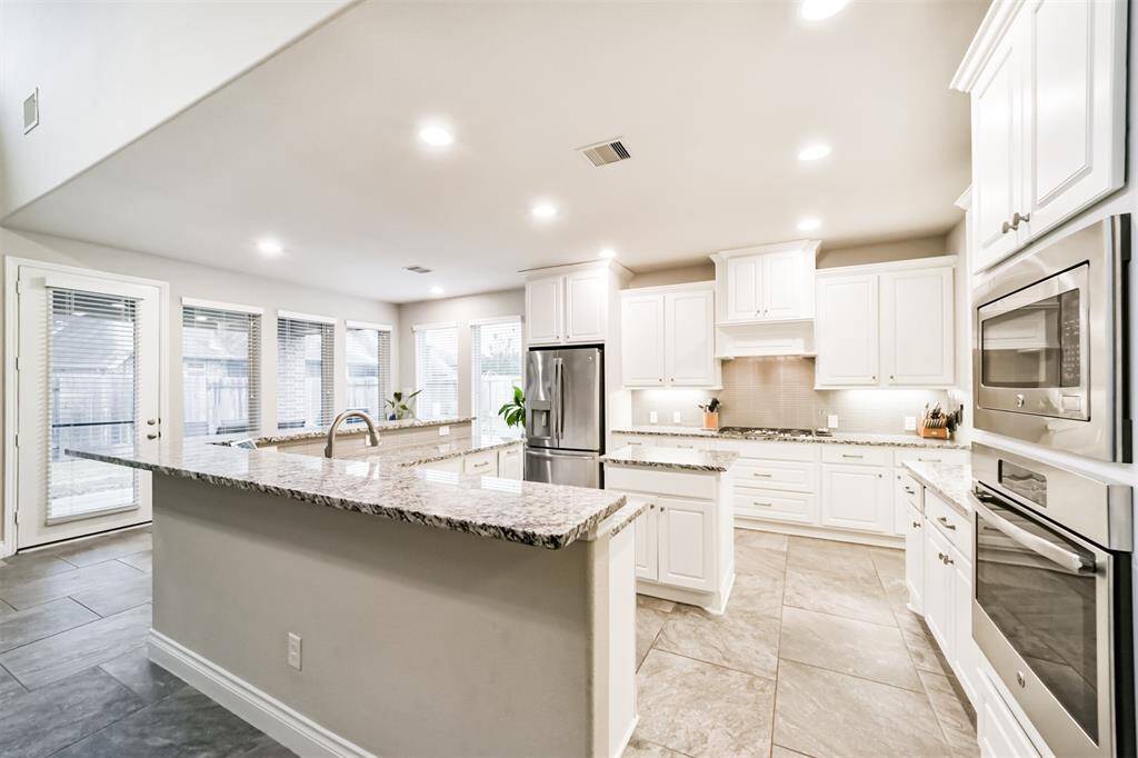 This oversized chef's style kitchen is perfect for entertaining. Ample counter & cabinet space along with a gas cooktop, convection oven and microwave. Nice details in the designer back splash and undercabinet lighting .