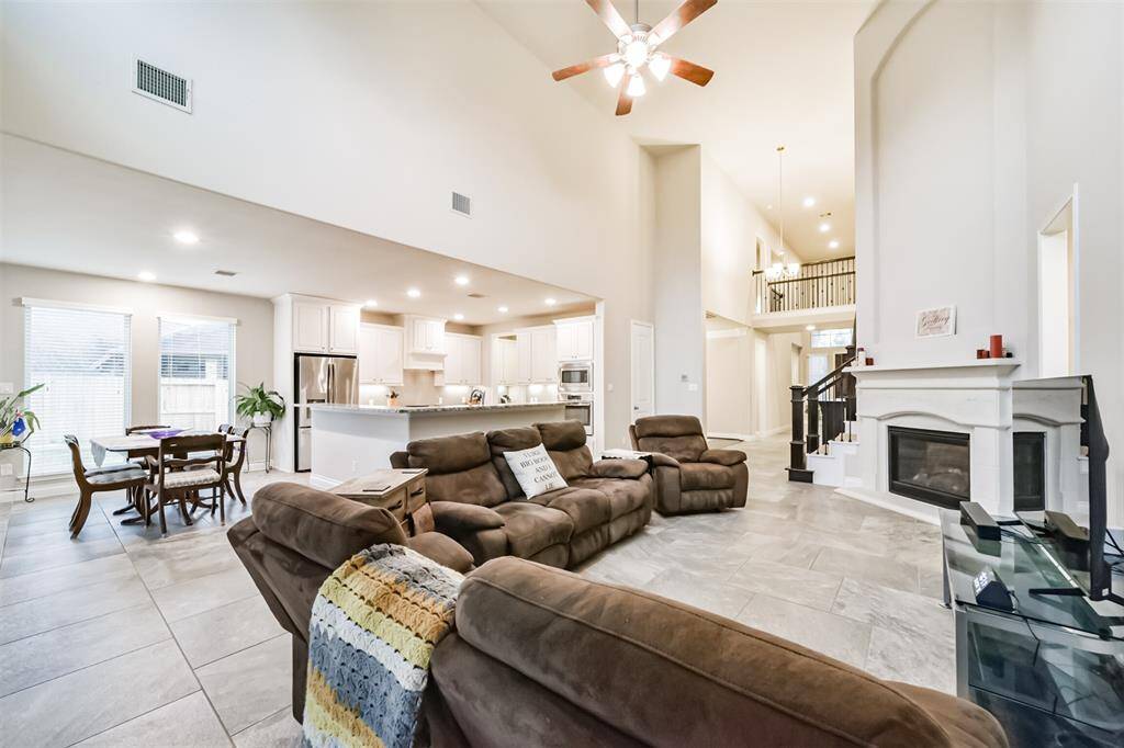 The family room features soaring ceilings, allowing for for an abundance of natural light. A cast stone fireplace adds and touch of elegance and warmth creating a cozy yet grand family space. The open concept seamlessly connects the kitchen and breakfast area, making ti perfect for bith entertaining and everyday living.