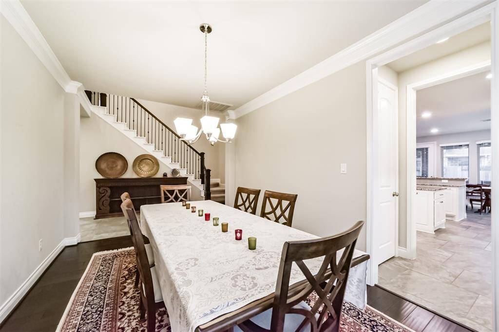 A spacious dining room with elegant lighting, opens to the foyer and butler's pantry leading to the kitchen. Large enough for family dining and holiday guests.