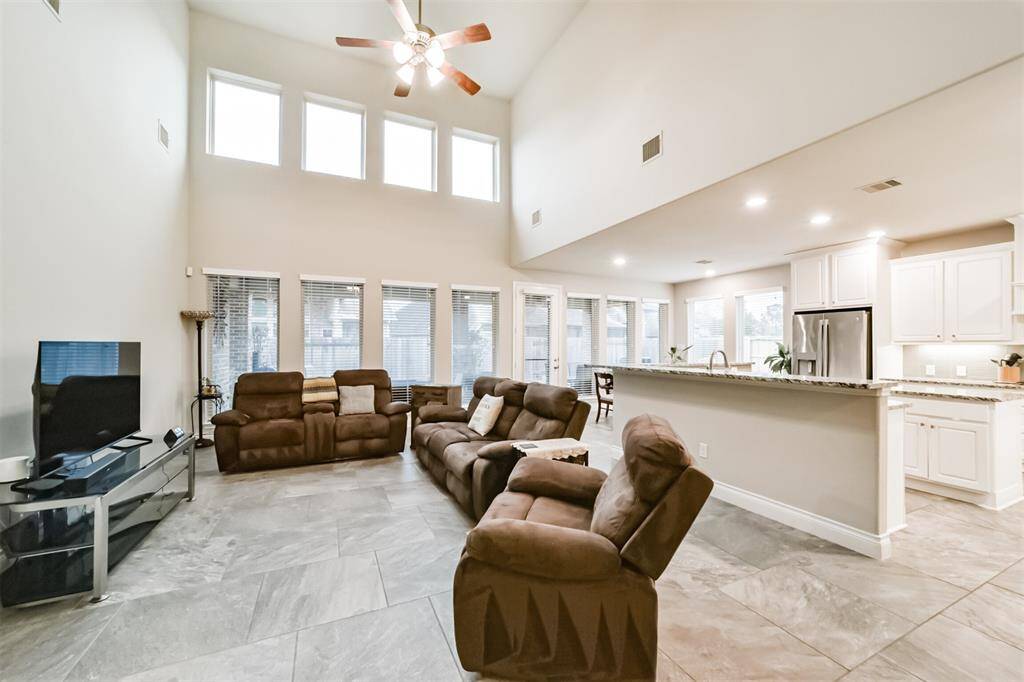 Secondary view of the family room showcase the expansive windows that frame the large covered patio and spacious backyard.