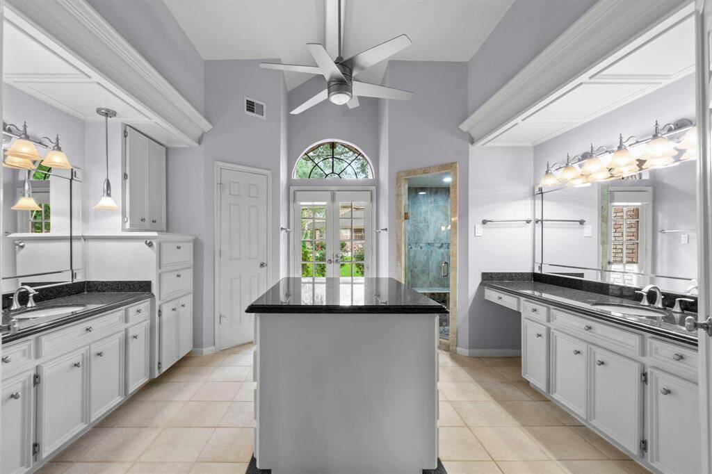 Look at this primary bathroom! Swoon worthy! Two separate vanities and two separate sinks! The island in the center has drawers on both sides! So much storage! And so much natural light!