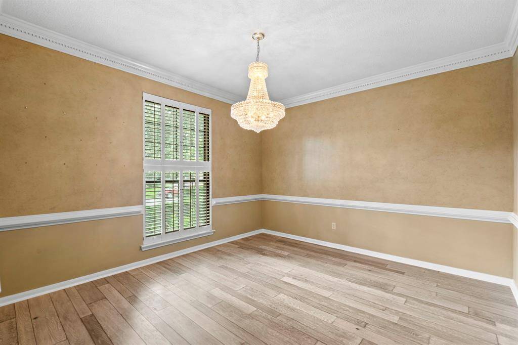 The dining room will be to your left as you enter, and it has windows facing out toward the street. Look at the engineered hard wood floors, the white trim, baseboards, chair rails and crown molding! Shutters on the windows too!