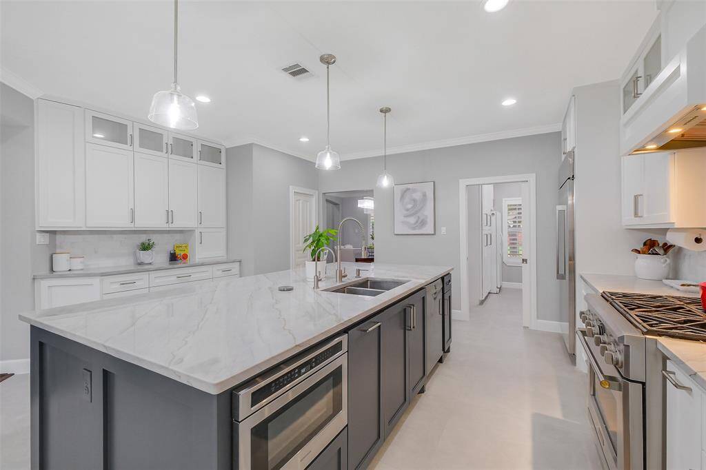 A chef’s kitchen reimagined with timeless elegance—featuring sleek quartz countertops, soft-close custom cabinetry, and designer pendant lighting that elevates the entire space.