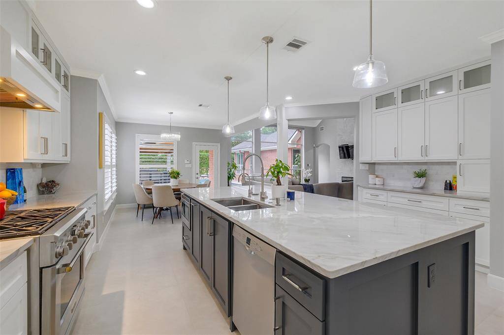 Sophisticated by design, the kitchen boasts integrated paneling, a professional-grade range, and artfully placed lighting—crafted for both culinary excellence and effortless entertaining.