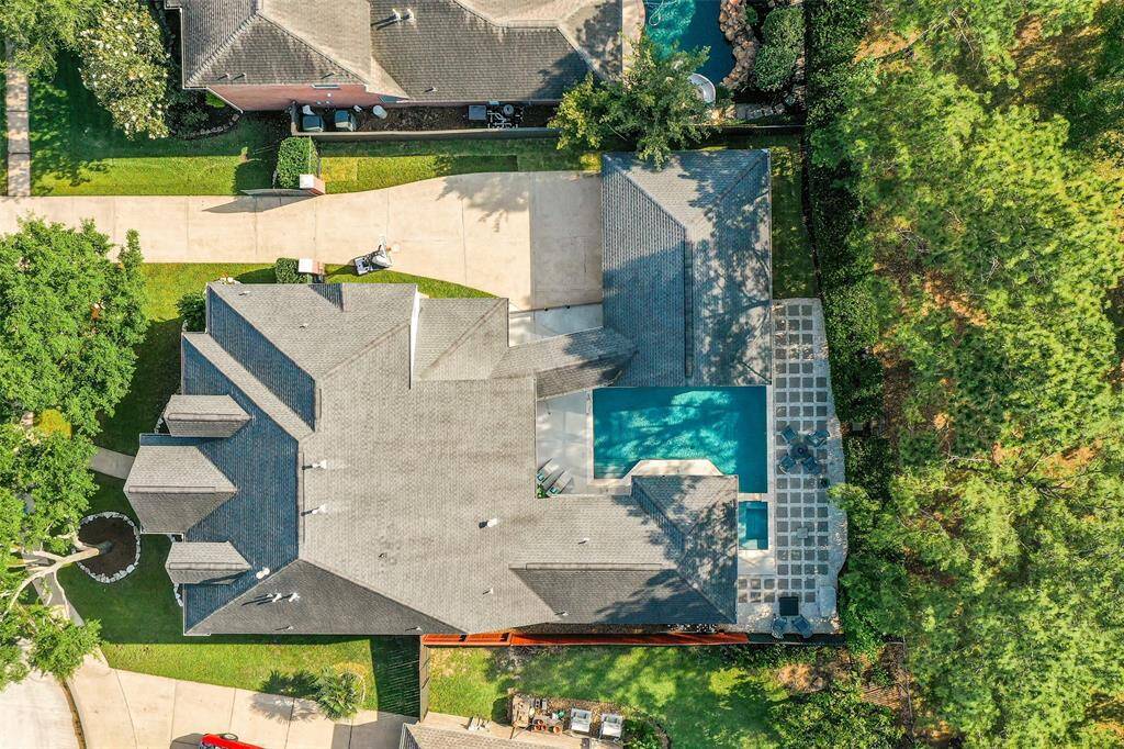 From above, this exquisite two-story brick estate reveals its full grandeur—nestled on a spacious, landscaped lot with a sparkling backyard pool as its centerpiece. Surrounded by lush greenery and elegant stonework, the outdoor oasis flows seamlessly from the home's stately architecture, creating a private retreat of timeless beauty.