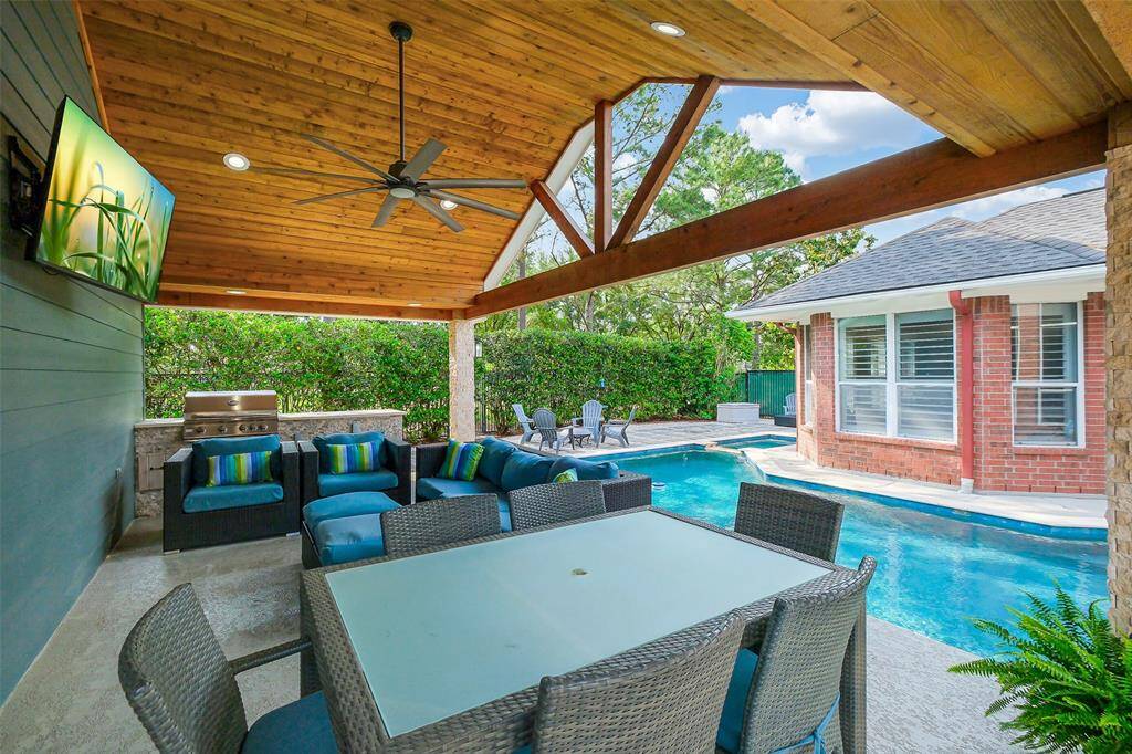 The backyard is a private oasis, with a sparkling pool at its center, reflecting the clear blue sky. Lush greenery surrounds the area, offering both beauty and privacy. Tall palms and vibrant flowers line the edges, while a stone pathway leads to cozy seating areas. The pool’s gentle ripple creates a peaceful ambiance, and the sun-drenched space is perfect for both relaxation and entertainment.