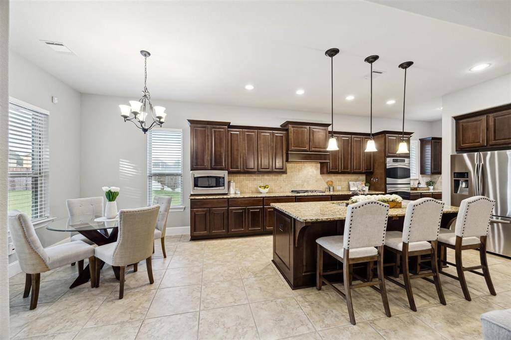Bright and inviting kitchen with a cozy breakfast nook, featuring soft close cabinetry, modern appliances, and a spacious island for seamless dining and entertaining.