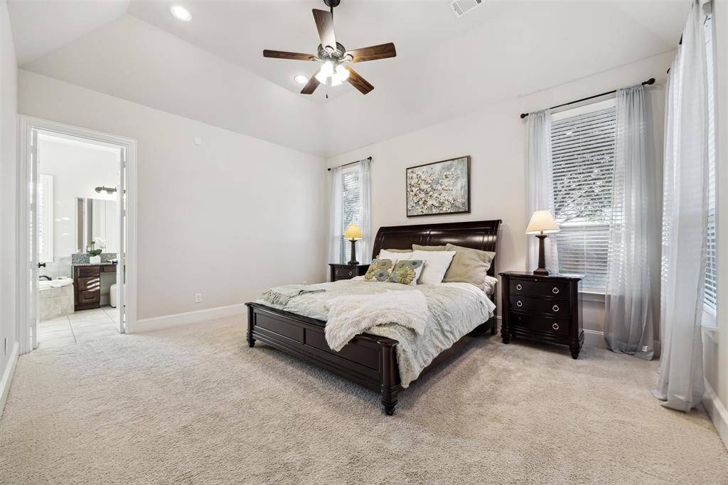 Spacious and serene primary bedroom with an en-suite bathroom, featuring elegant finishes and ample natural light.