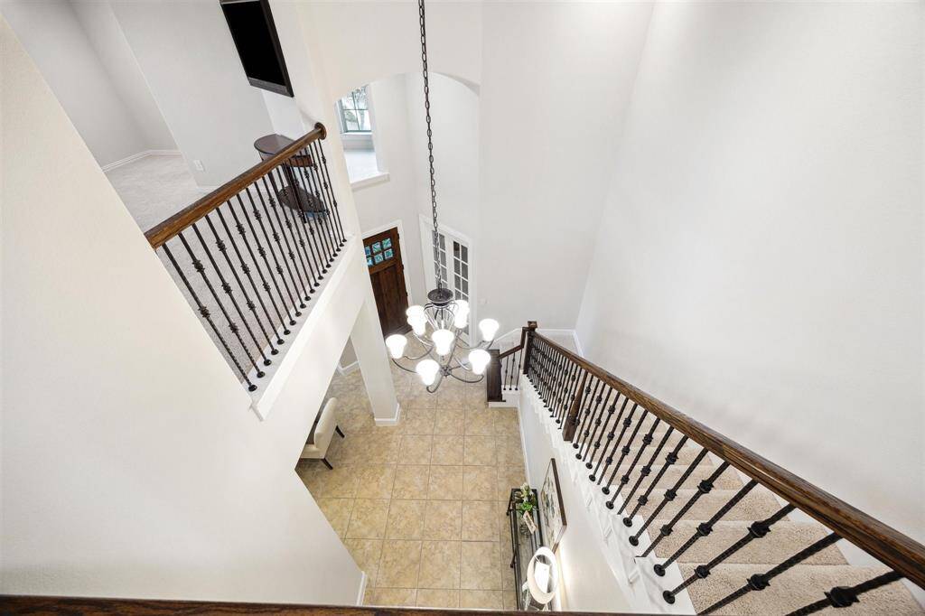 A stunning chandelier enhances the beauty of the stairwell.