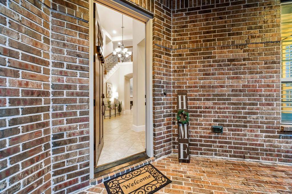 Inviting entryway with elegant lighting and warm brick accents.