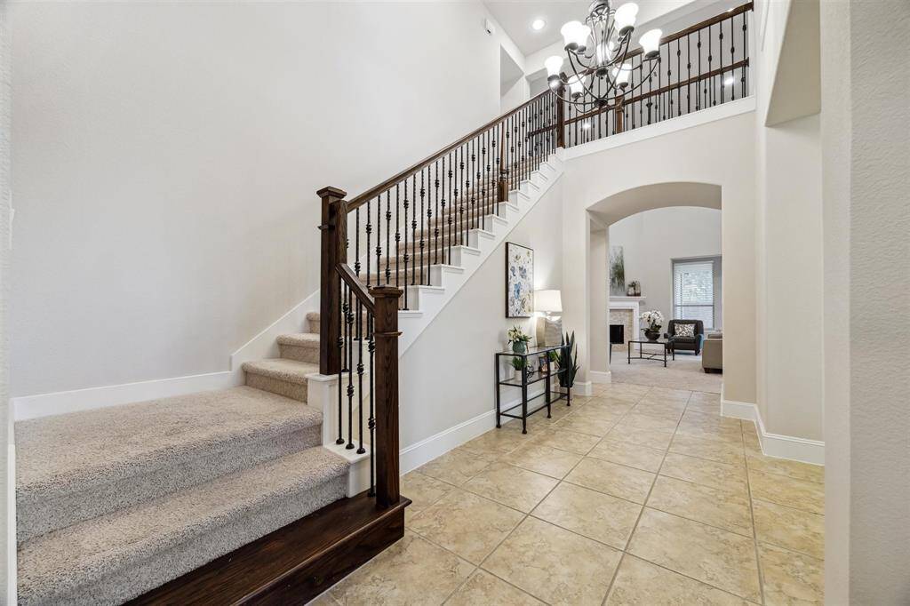 Experience an impressive entrance with a soaring ceiling and elegant staircase, setting the tone for this stunning home.