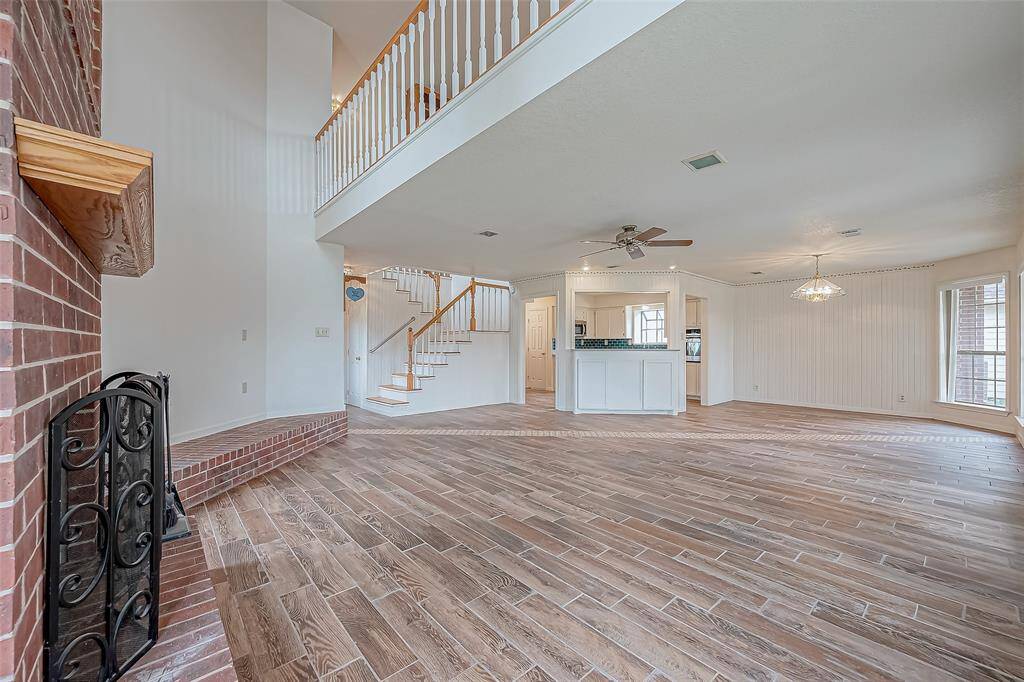 Looking up, the home’s dynamic layout comes into full view—soaring ceilings give way to the second-floor loft, overlooking the living space below. This open design keeps the home feeling connected, offering a perfect balance between spaciousness and warmth.