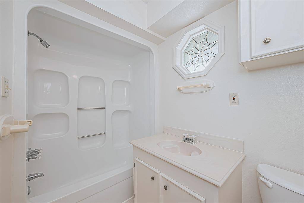 This private en suite bath is designed for efficiency without sacrificing style. The vanity sink offers storage for essentials, while the full bath setup ensures convenience.