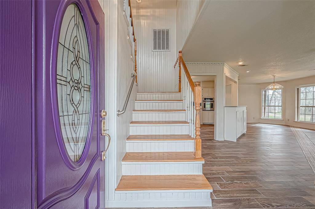 From this vantage point, the entry unfolds into a bright and open layout, inviting movement throughout the home. The gleaming floors reflect light beautifully, enhancing the sense of space. The staircase, positioned just to the side, subtly defines the area without interrupting the flow.