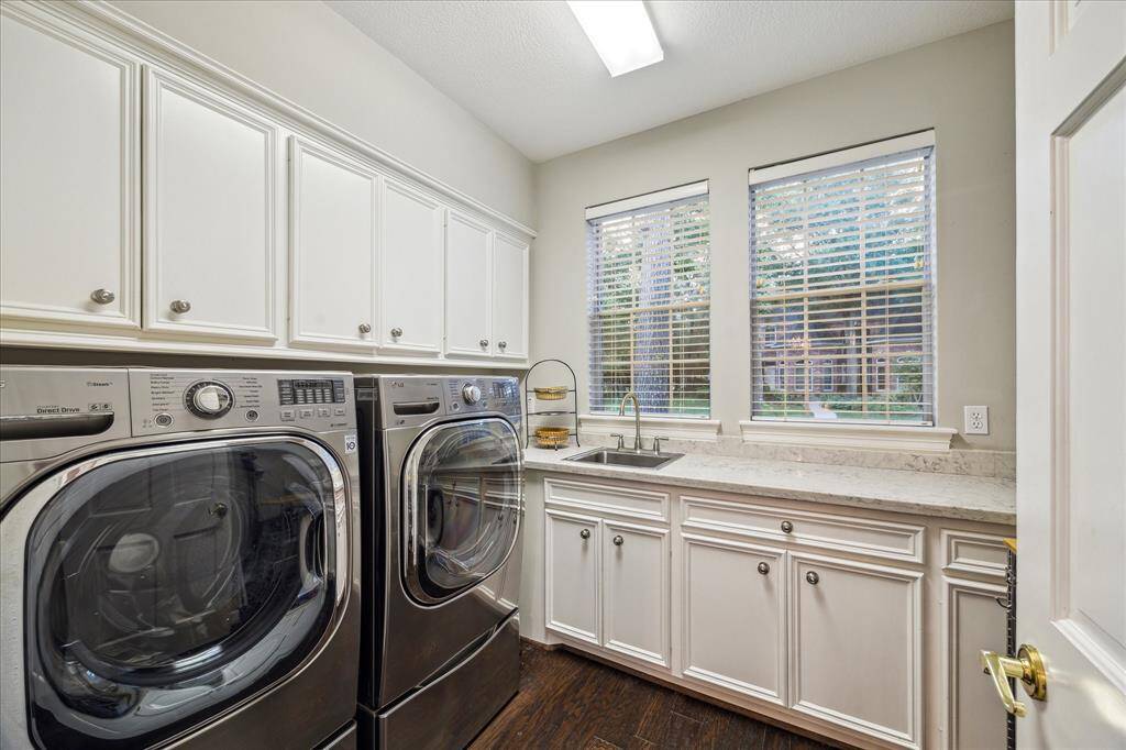 Spacious laundry room with plenty of cabinet storage and sink!