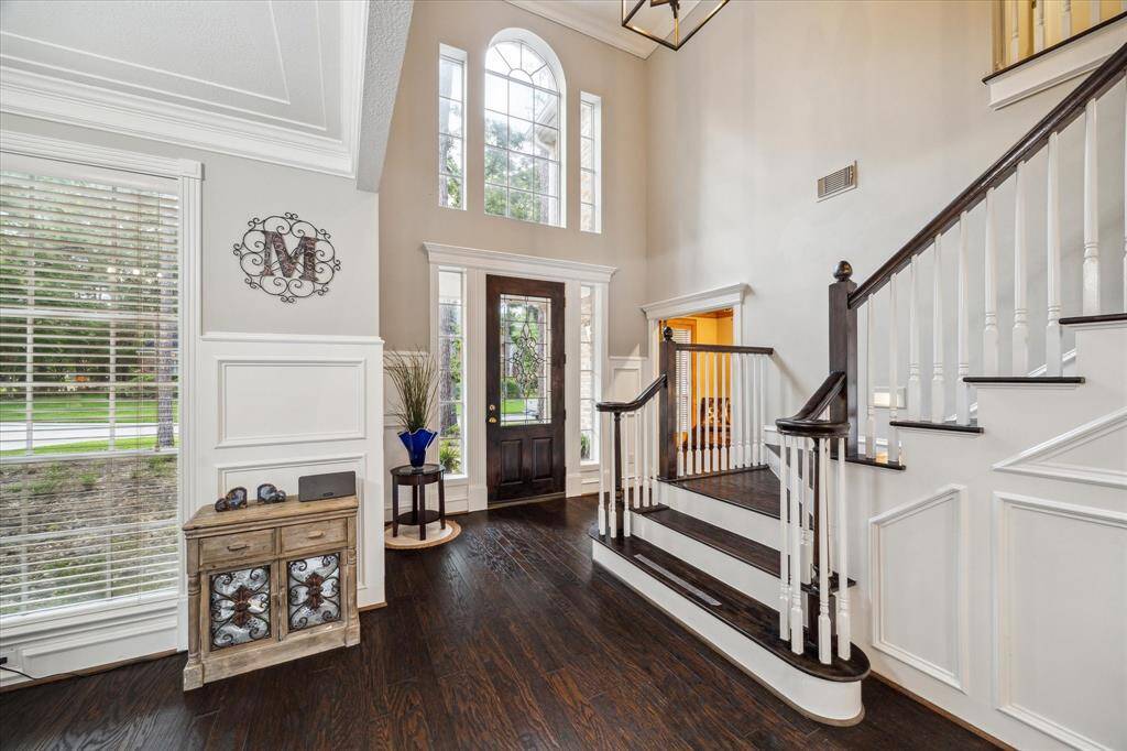 The entry boasts rich hardwood flooring and high ceiling with plenty of natural light.