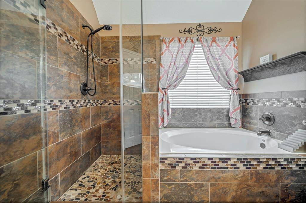 RICH GRANITE WELCOMES YOU INTO THE PRIMARY BATH AREA.