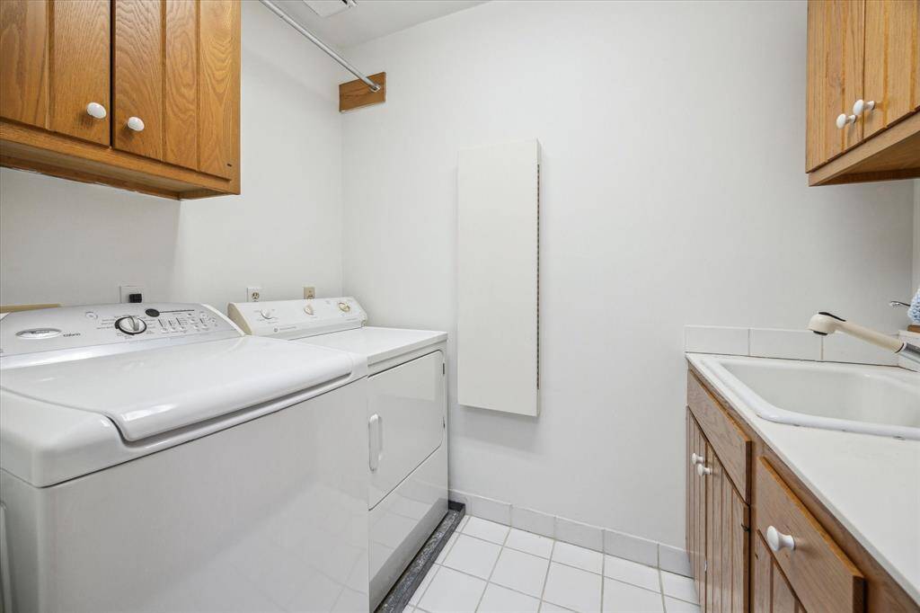 Utility on the 2nd floor w/ storage, a hanging rack and sink.