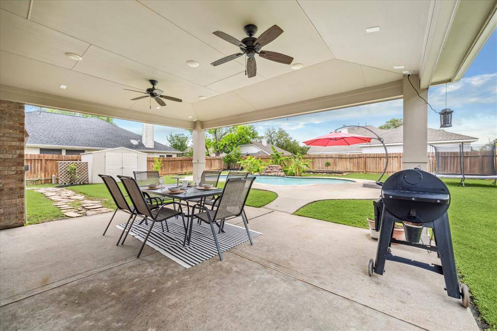 Large oversized covered patio overlooking large pool and huge corner lot.