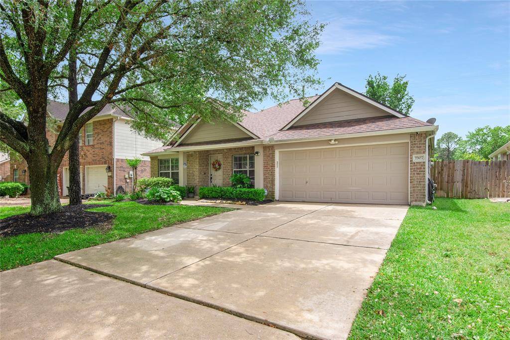 Charming single-story brick home with a well-maintained front yard, mature trees, and a welcoming entryway.