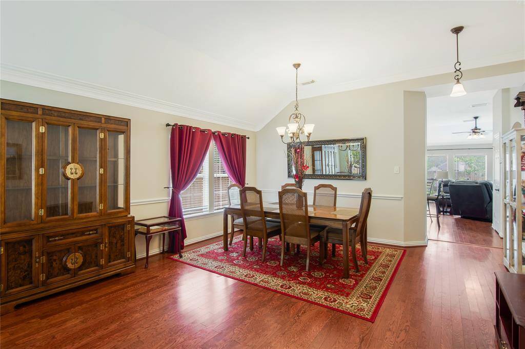 The dining area offers a warm and inviting ambiance with beautiful hardwood floors, seamlessly flowing into a bright living space filled with natural light.