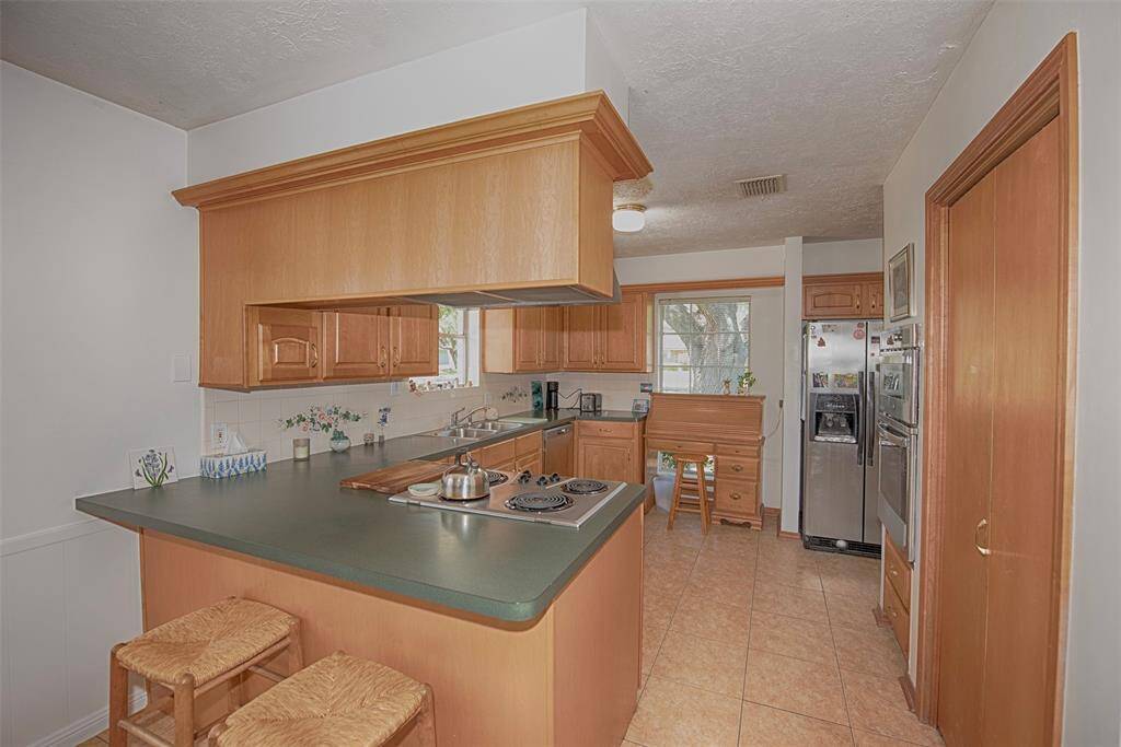 Kitchen also provides a great breakfast bar for enjoying your morning coffee or meals on the go for the little ones. Pantry is behind the doors to the right of the island.