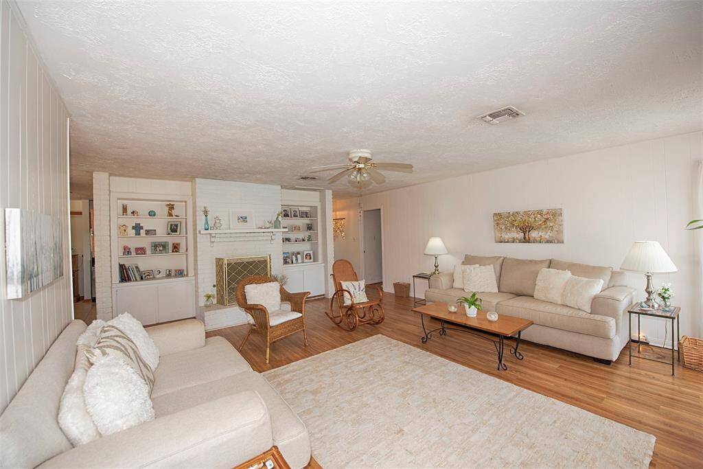A view of the family room showing the amazing space as well as the built in book shelves and storage. Book Shelves are perfect for books, family photos and collectibles.  Also features a wood burning, gas fireplace.