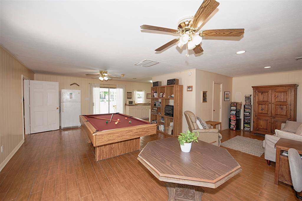 The game room has been updated with the beautiful wood look tile and has sliding doors to the patio and pool.