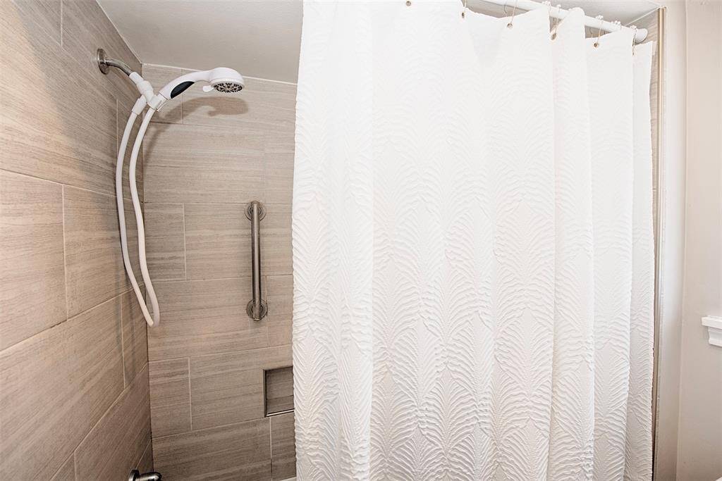 Updated combo bath and shower with safety bar and niche for your soap and shampoo.