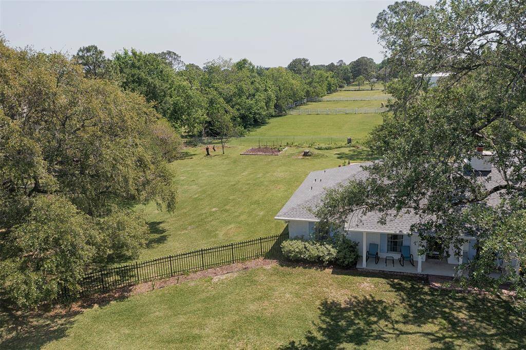 An aerial view from the front yard showing the wrought iron gate to the huge backyard.