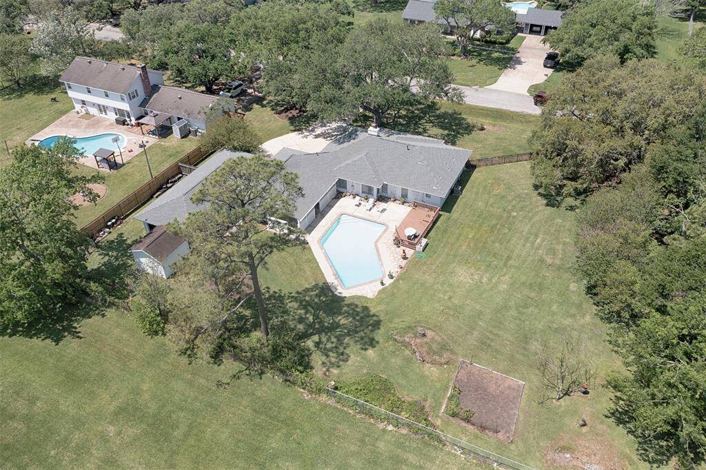 Another aerial of the home showing the expansive yard and pool. To the right of the yard is a wall of trees providing great privacy.