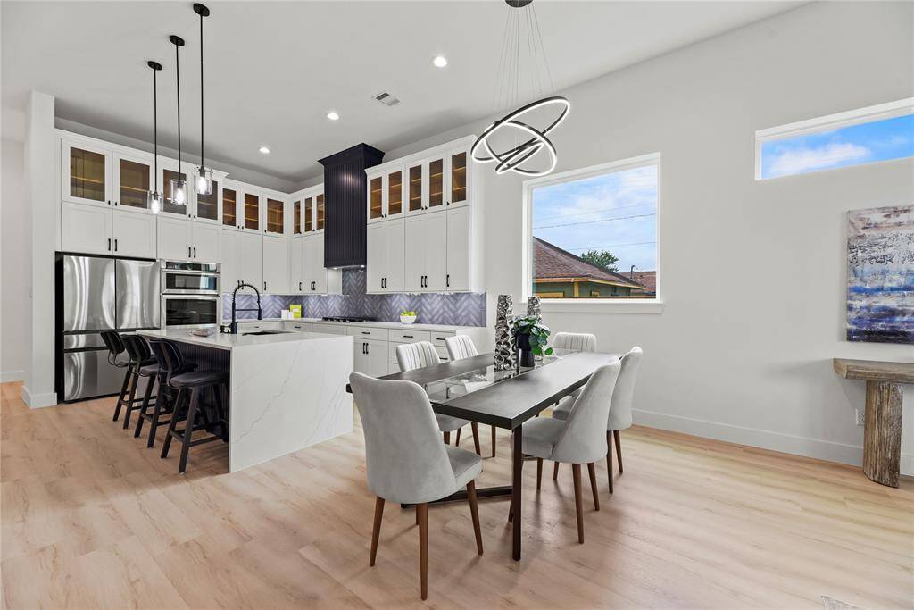 Another viewpoint of of the gorgeous kitchen and dining areas showcases the seamless flow between the spaces, where modern finishes, designer lighting, and and elegant quartz surfaces come together to create a truly elevated living experience.