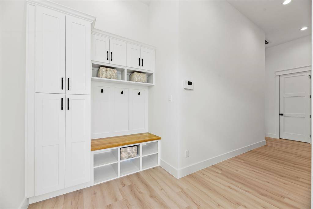 The entryway also hosts an oversized mudroom with solid wood bench maximizing comfort while also offering ample storage and functionality with stylish design.