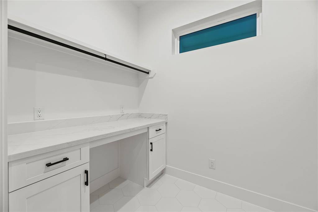Quartz folding table with soft close drawer and additional cabinetry space and hanging rod.