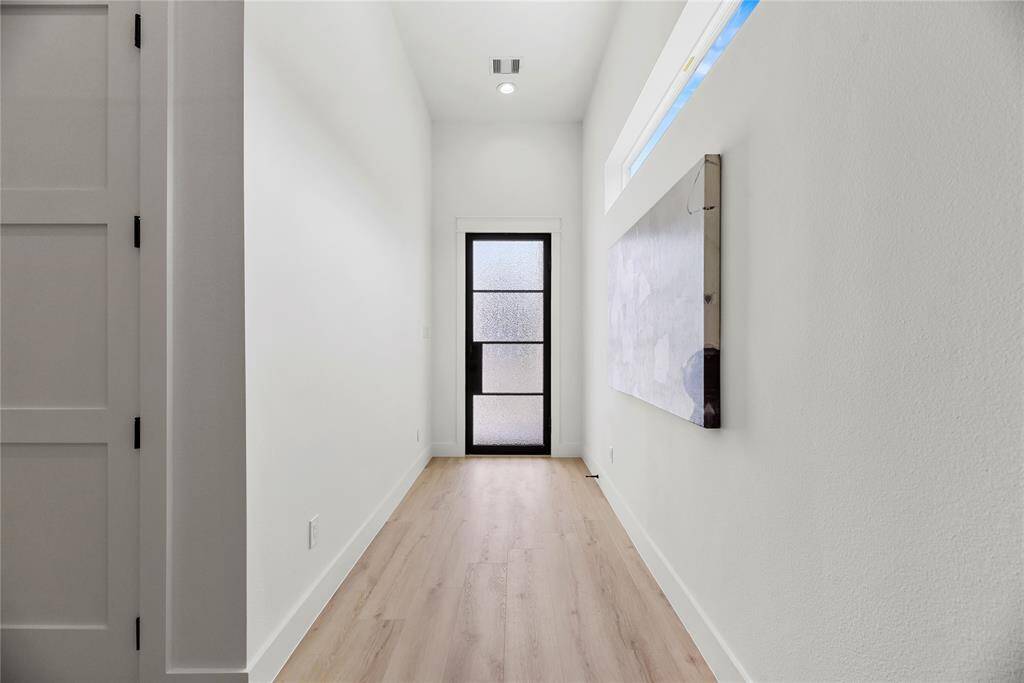 Private entry corridor with elevated ceiling and contemporary elongated fixed window.