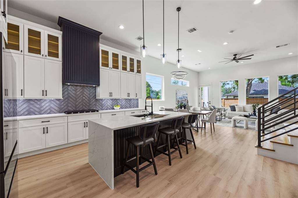 The kitchen provides the perfect blend of luxury and practicality. This luxurious kitchen really brings the culinary experience with extended quartz countertops, a truly impressive fully functional 8'3" X 3'3" custom quartz island, soft-close cabinetry with glass inserted uppers and beautiful illumination from the undermounted cabinet lighting all coming together truly enhancing this kitchen.