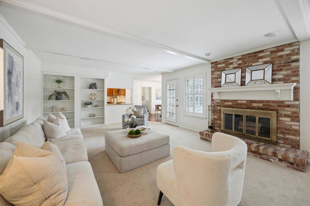 Family room with access to the kitchen, upstairs and backyard boasts traditional wood beams and gas fireplace.