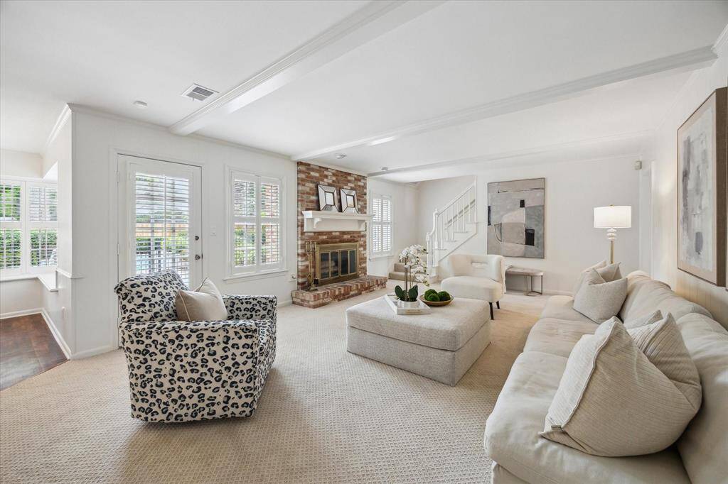 Family room with access to the kitchen, upstairs and backyard boasts traditional wood beams and gas fireplace.