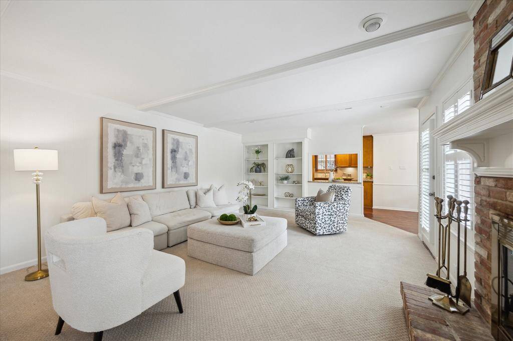 Family room with access to the kitchen, upstairs and backyard boasts traditional wood beams and gas fireplace.