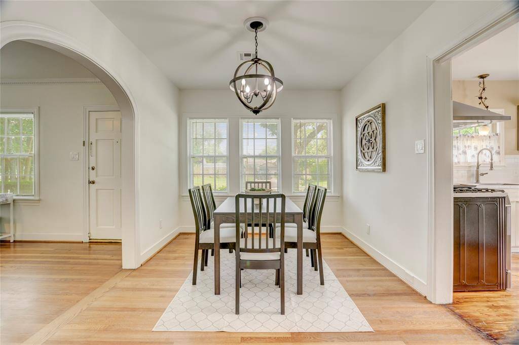 Separate dining room with a modern chandelier has plenty of space to hold formal dining for 8.