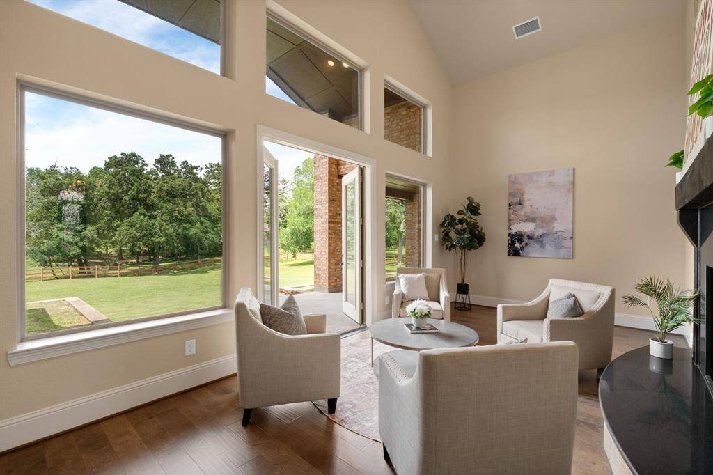With serene backyard views, this sun-drenched sunroom offers the perfect blend of comfort and connection to nature. With the warmth of a two-sided stone fireplace shared with the family room, this space exudes charm, relaxation, and year-round livability.