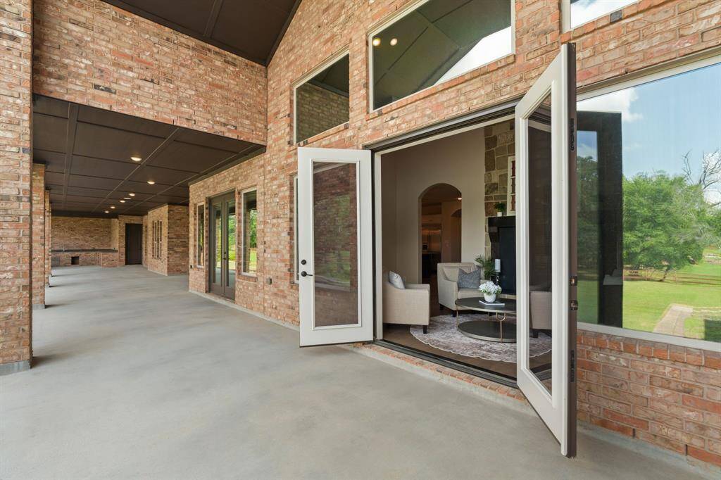 Open the glass doors in the sunroom to extend your living space onto the expansive covered patio that runs the full width of the home. Complete with a built-in summer kitchen, it's ideal for effortless indoor-outdoor entertaining.