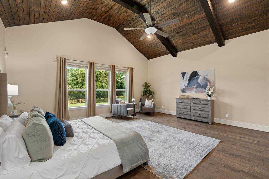 The primary bedroom is a serene retreat, featuring engineered wood flooring and a cathedral wood-slat ceiling that adds architectural charm. Oversized windows flood the room with natural light, while the custom walk-in closet is outfitted with a dressing table and custom built-ins for ultimate organization. The spa-like ensuite boasts separate vanities, a Greek shower, and a free-standing tub, offering the perfect space to relax and unwind.