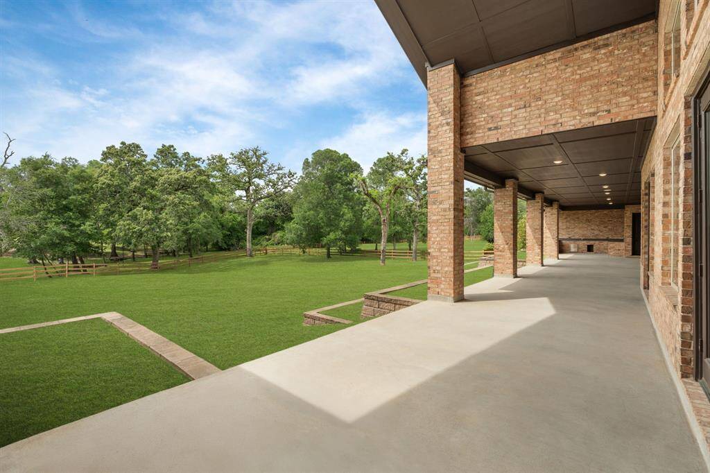 The covered patio extends the full width of the home, offering stunning views of the expansive 1+ acre yard. With a summer kitchen perfect for outdoor cooking and entertaining, the patio overlooks lush landscaping and is equipped with a sprinkler system for easy maintenance. Situated on a corner lot, this backyard provides both privacy and a peaceful, scenic environment for relaxation and gatherings.