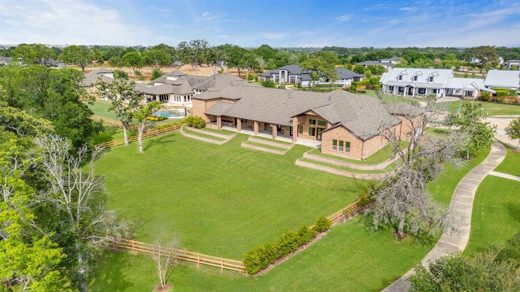 This view of the back of the home and backyard showcases the expansive outdoor space, offering plenty of room for your new pool. With a serene backdrop of the greenbelt, the backyard provides both privacy and a peaceful retreat, perfect for enjoying the outdoors while being close to nearby conveniences.