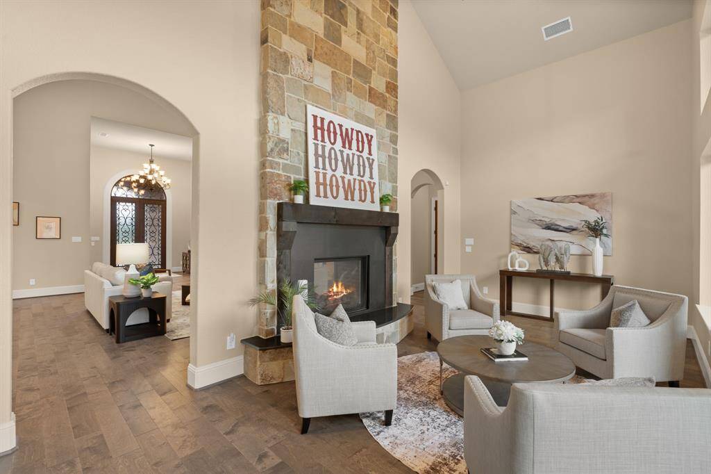 A true showpiece, the floor-to-ceiling stone gas-log fireplace commands attention with its timeless design and warm ambiance. This stunning two-sided feature opens to the sunroom on the opposite side, creating a seamless connection between relaxed living and sunlit serenity.