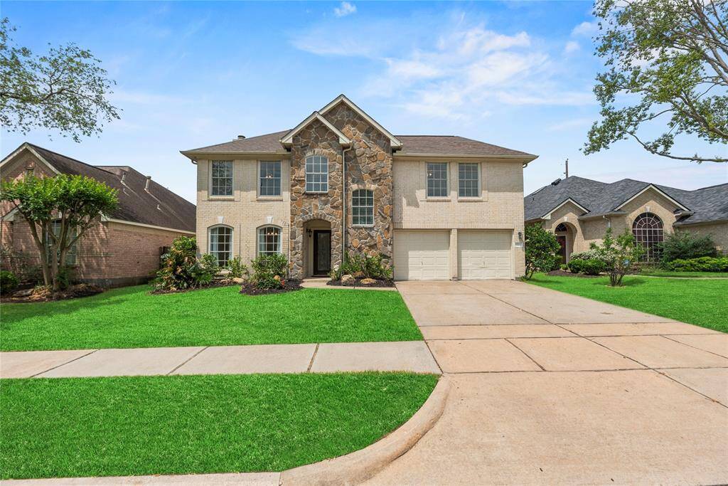 This stunning home features a captivating stone and brick exterior, lush landscaping, and an inviting entryway. Ideal for modern living, the property offers elegance and comfort in a prime location. Don't miss this opportunity!