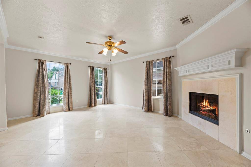Travertine Flooring throughout the first floor, creating a modern and luxurious space with a Gas Log Fireplace