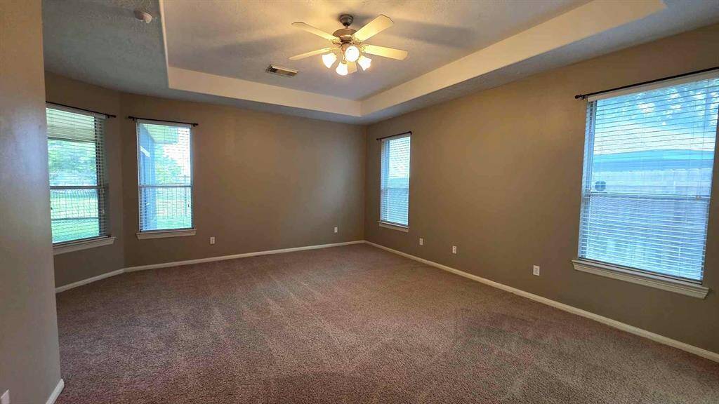 Entering your owner's suite with high tray ceiling and large windows